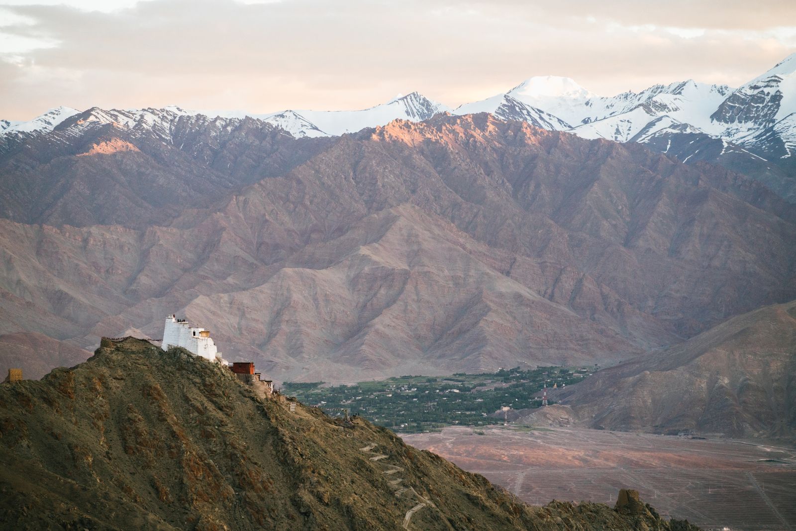 Monastère perché sur un éperon rocheux du Ladakh, sommets enneigés en arrière-plan