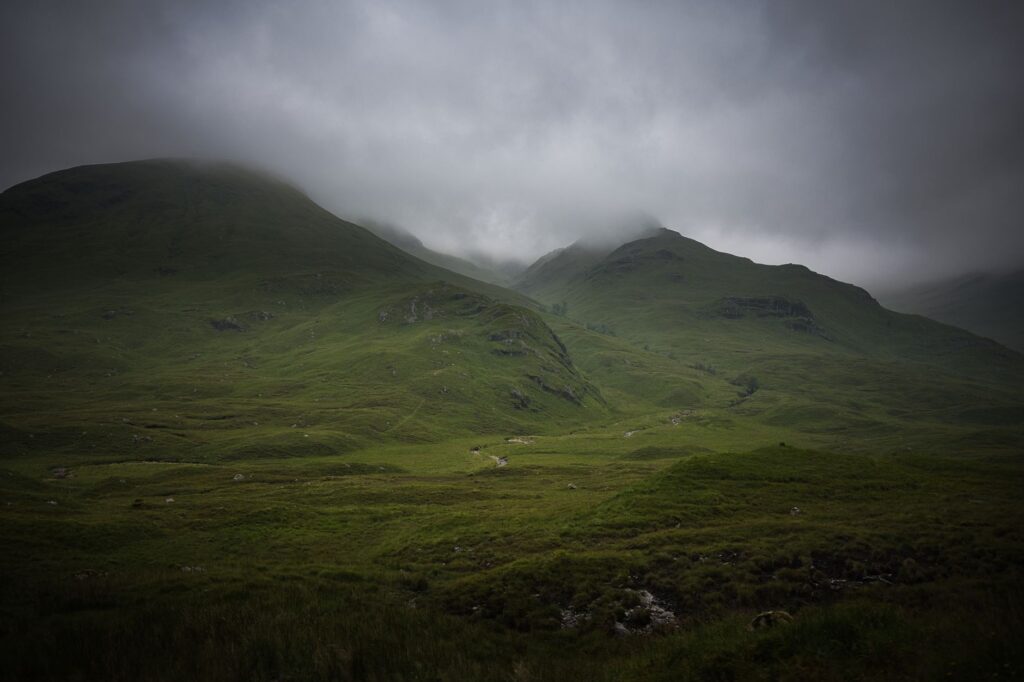 Collines verdoyantes des Highlands écossais noyées dans la brume
