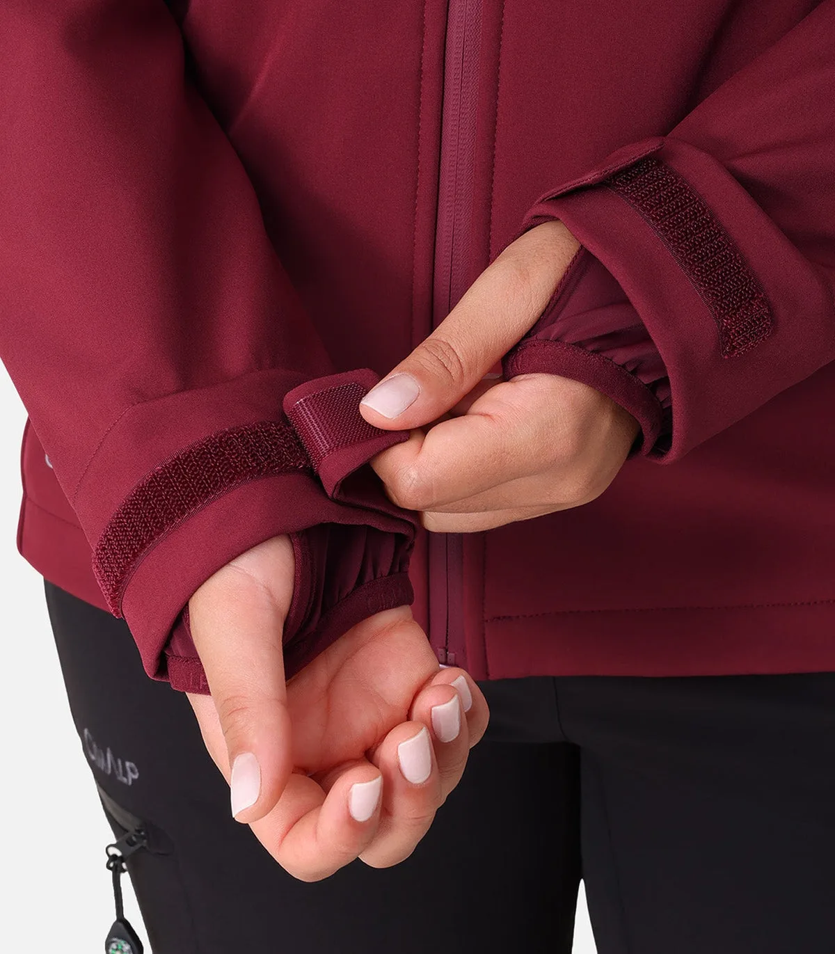 Gros plan sur le serrage velcro du poignet d'une veste de randonnée femme bordeaux Cimalp