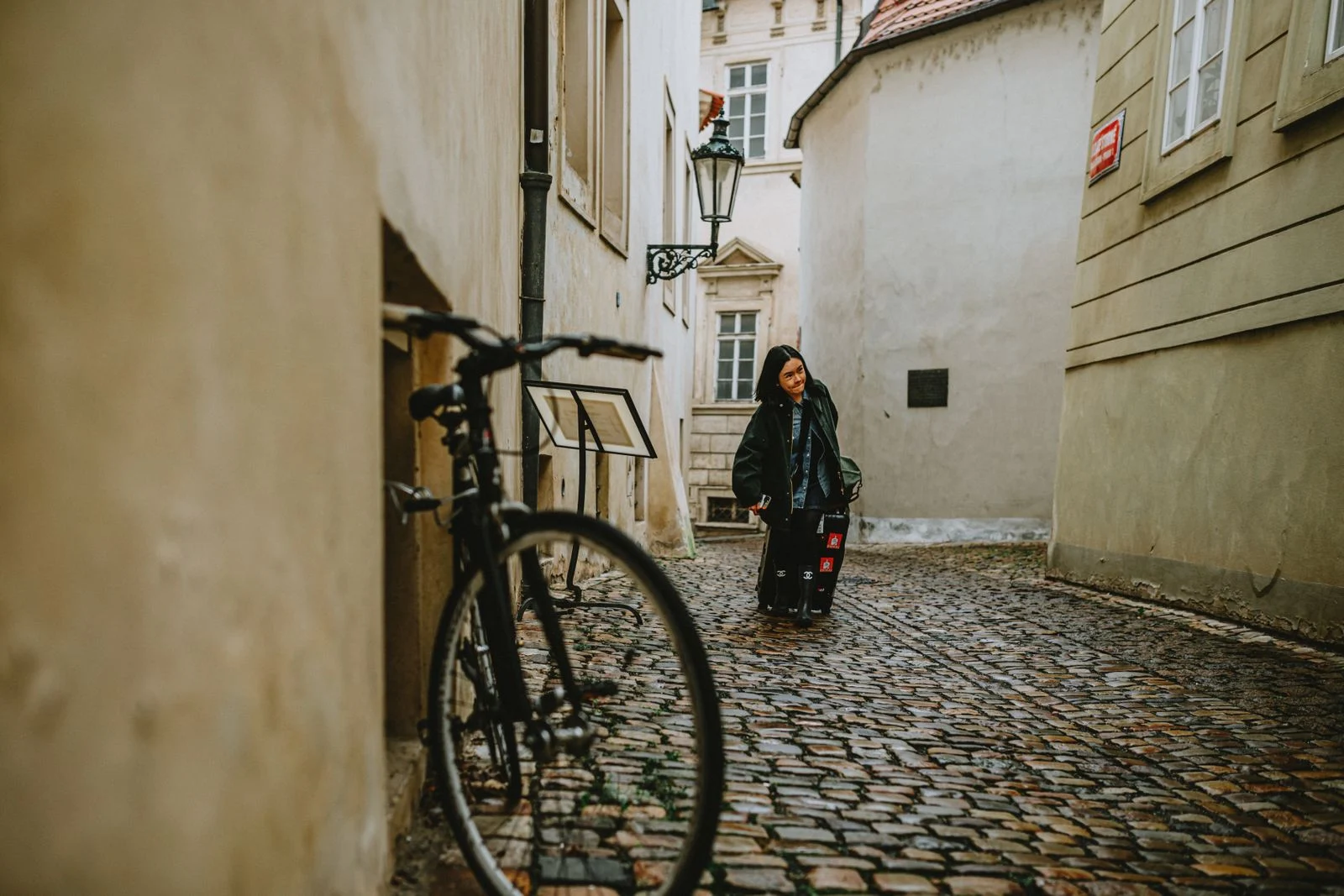 Ruelle pavée d'une vieille ville européenne avec un vélo appuyé contre un mur