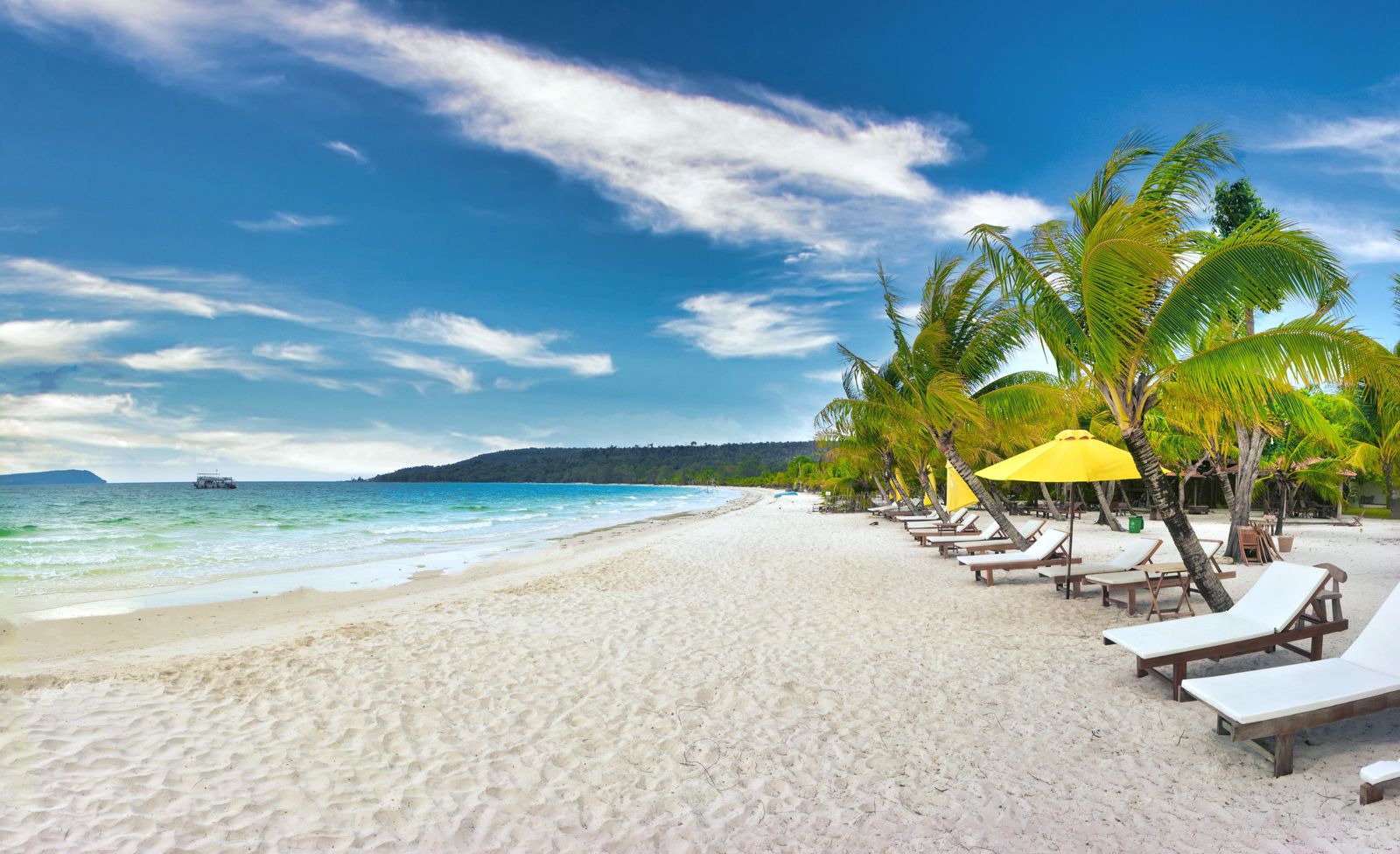 Plage de sable blanc bordée de cocotiers et de transats sur l'île de Koh Rong