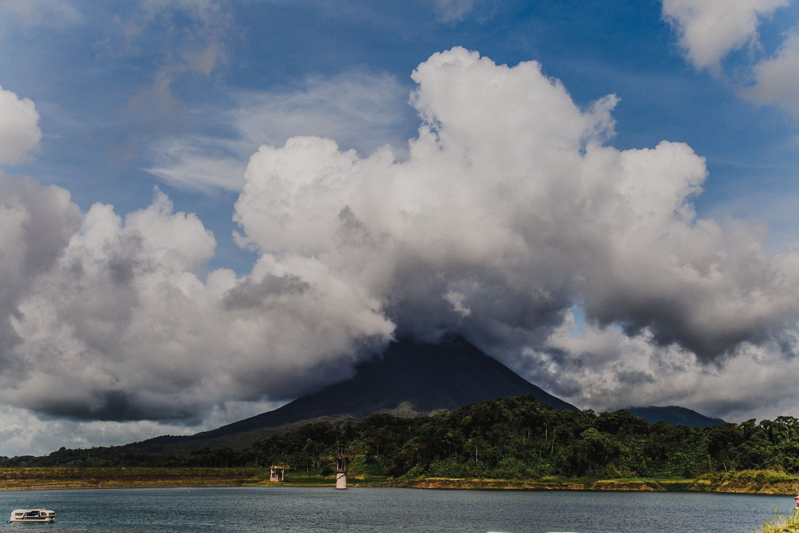 Le volcan Arenal sous de gros nuages, au-dessus d'un lac, au Costa Rica