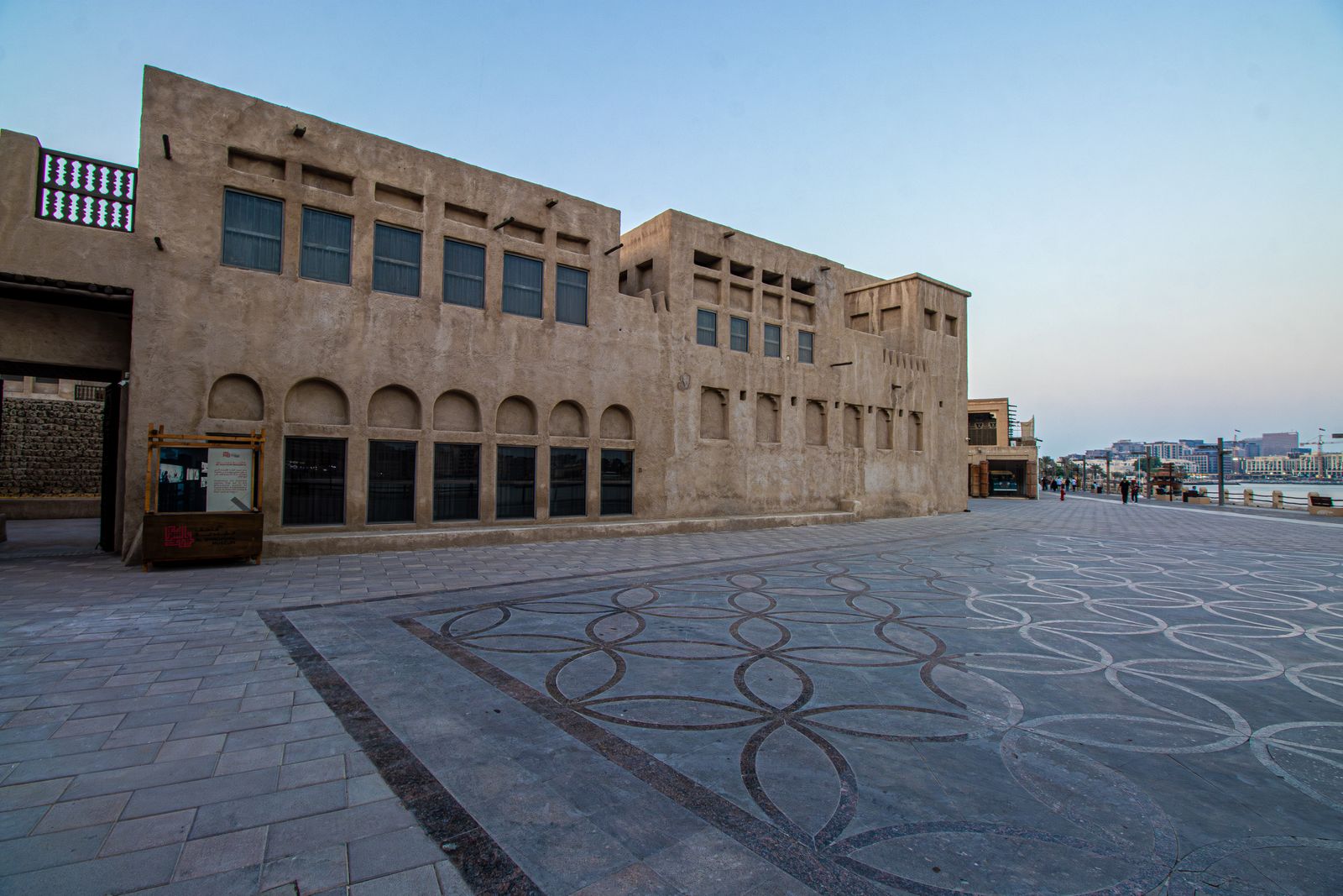 Maisons de pierre et place pavée du quartier historique d'Al Fahidi, le matin