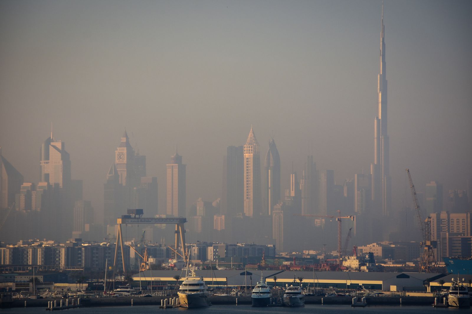 Gratte-ciel de Dubaï et Burj Khalifa dans la brume, au-dessus d'un port