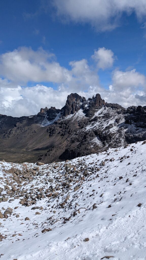 Neige au pied des pics rocheux du mont Kenya, sous un ciel bleu
