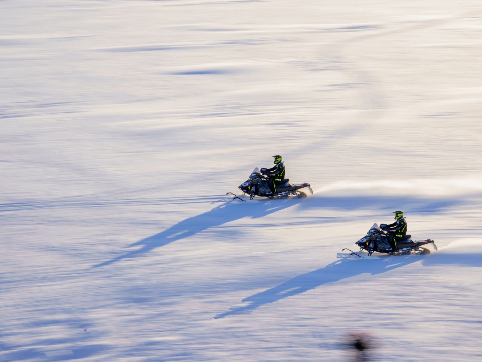 Deux motoneiges sur une grande étendue de neige en Laponie finlandaise