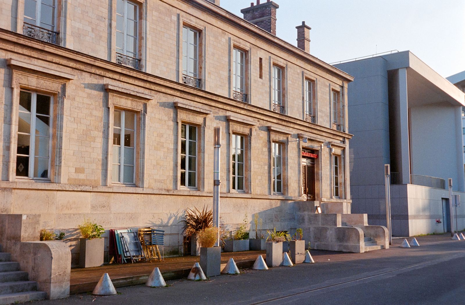 Façade d'un bâtiment ancien en pierre claire à Fort-de-France, avec son perron et des bacs de plantes