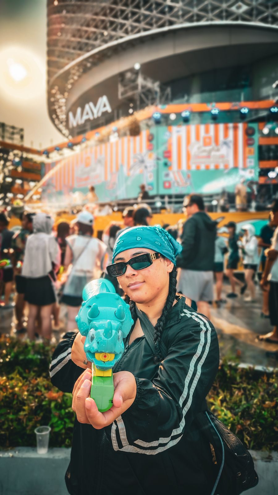 Participante armée d'un pistolet à eau pendant la fête de l'eau, devant le centre Maya à Chiang Mai
