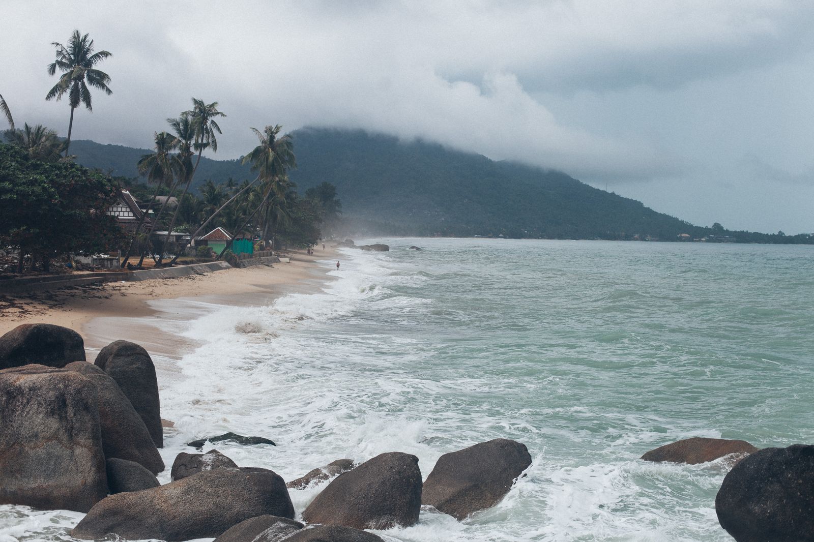 Vagues sur une plage rocheuse de Ko Samui sous un ciel couvert