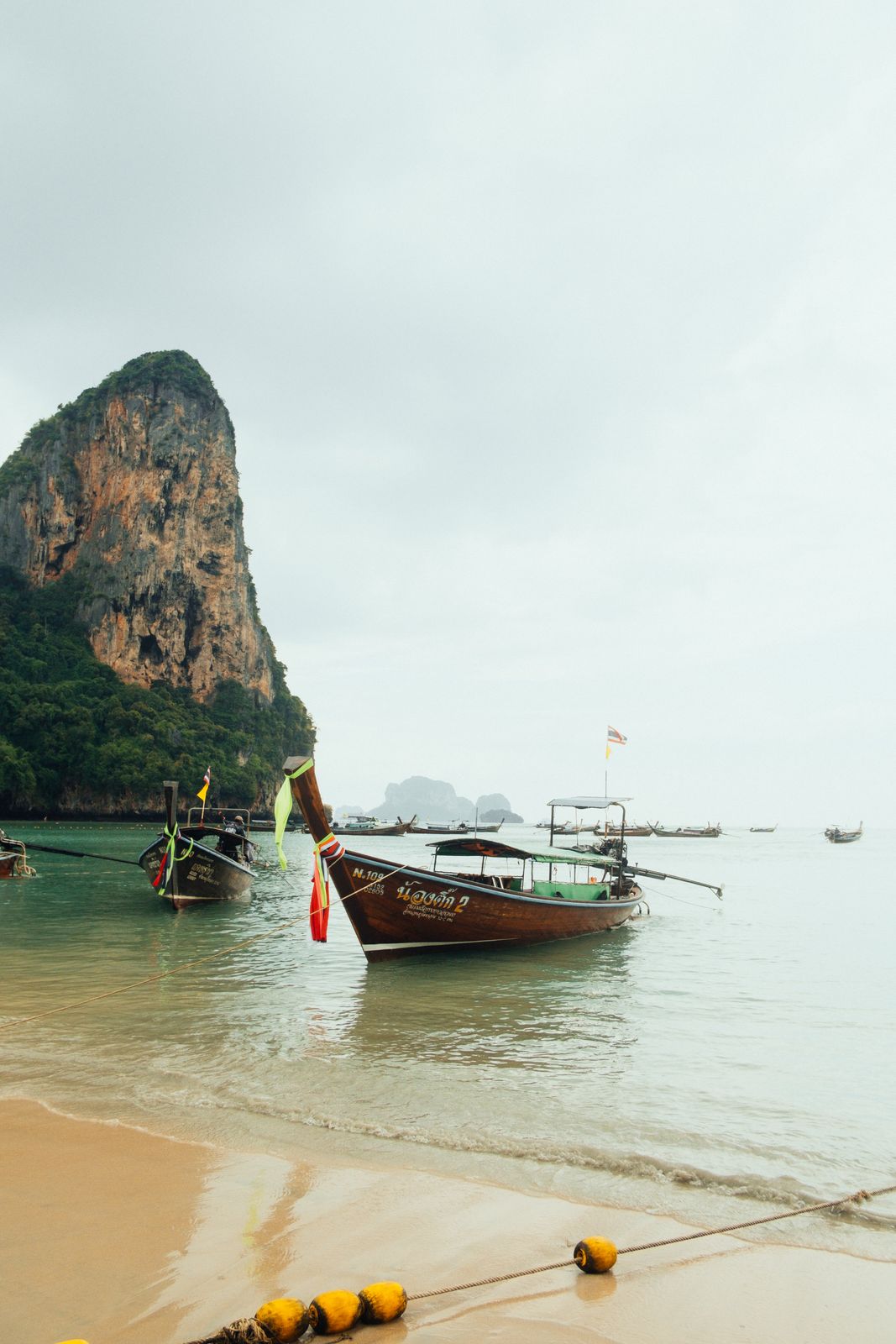 Bateaux à longue queue amarrés sur la plage de Railay, au pied des falaises calcaires