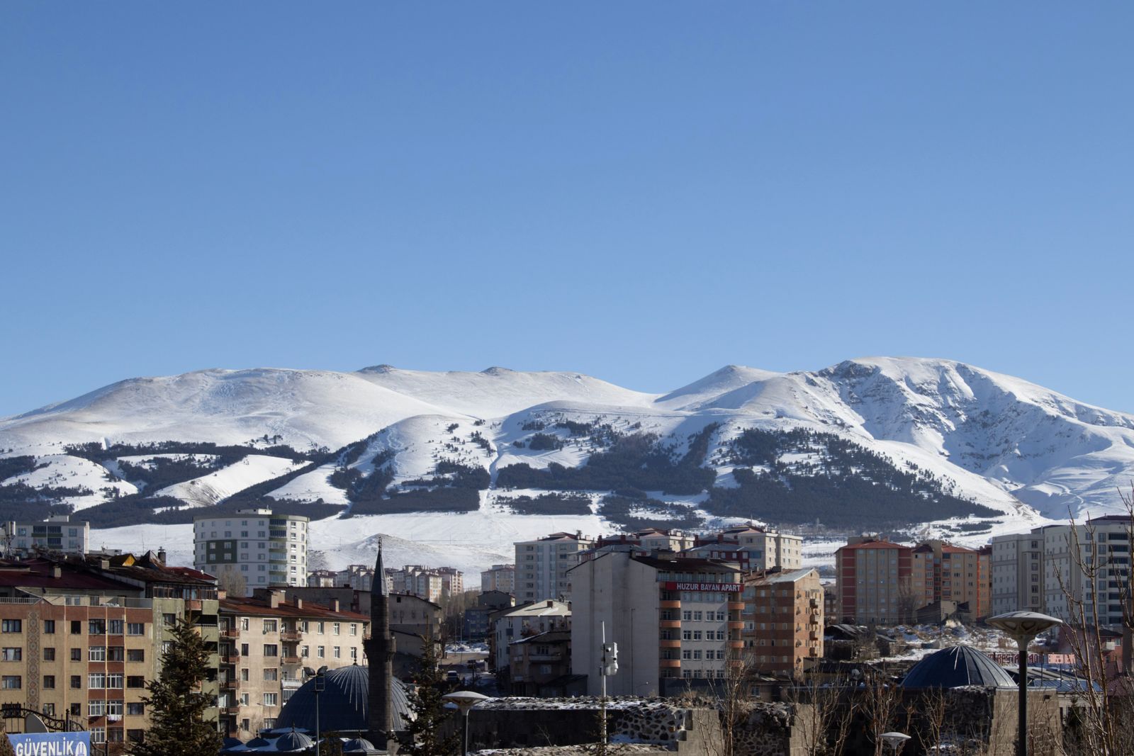 Les montagnes enneigées au-dessus des immeubles d'Erzurum
