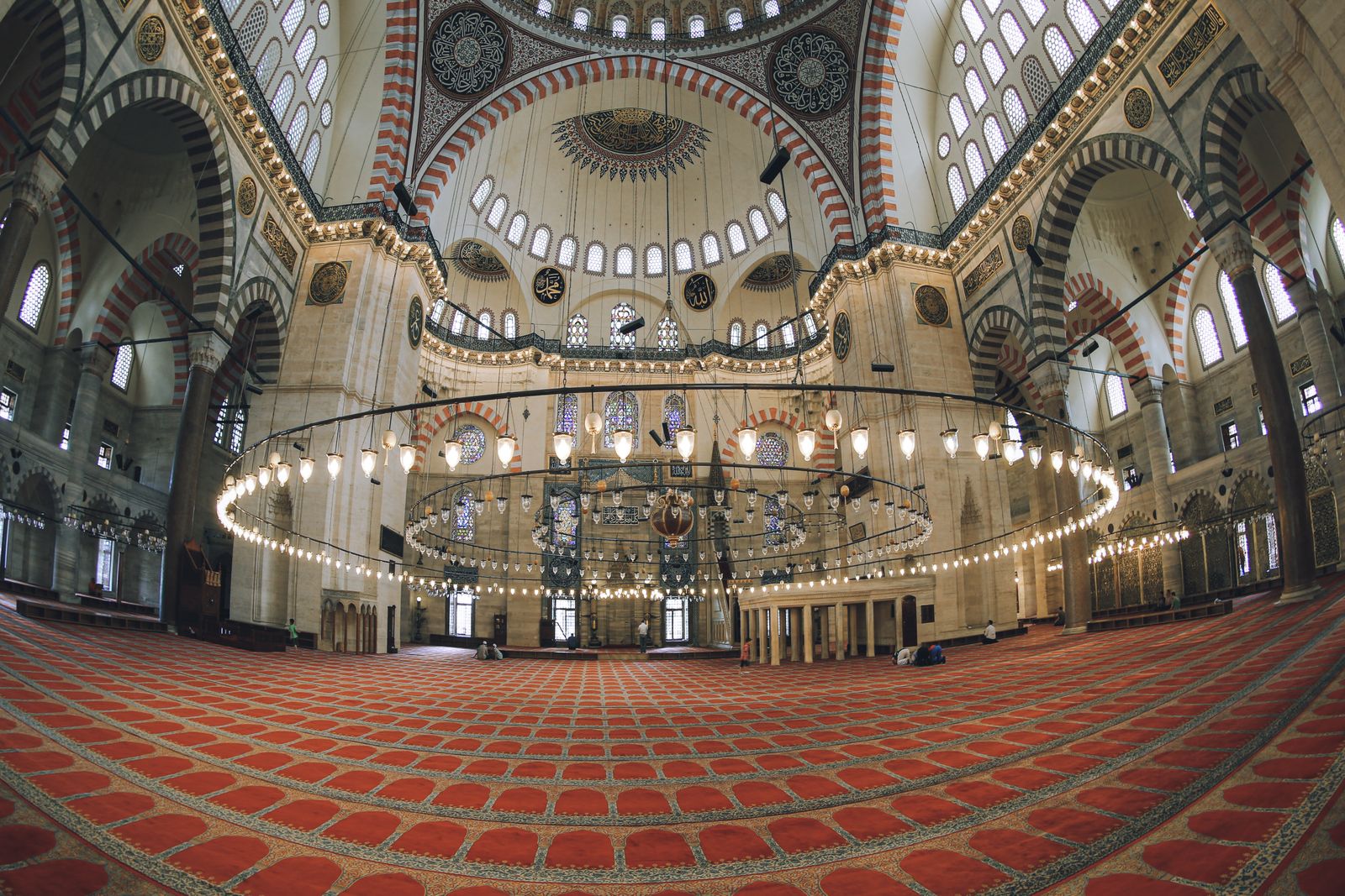 La salle de prière de la mosquée Süleymaniye, avec son tapis rouge et son grand lustre circulaire