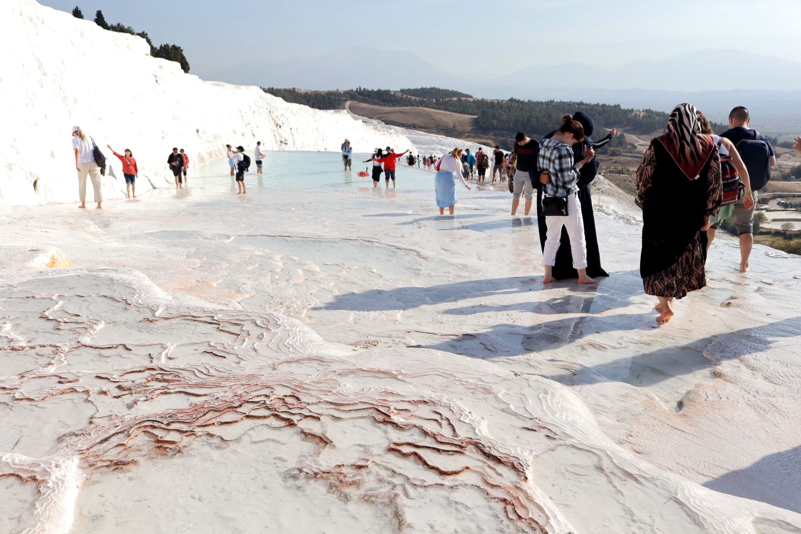Des visiteurs marchent sur les travertins blancs de Pamukkale
